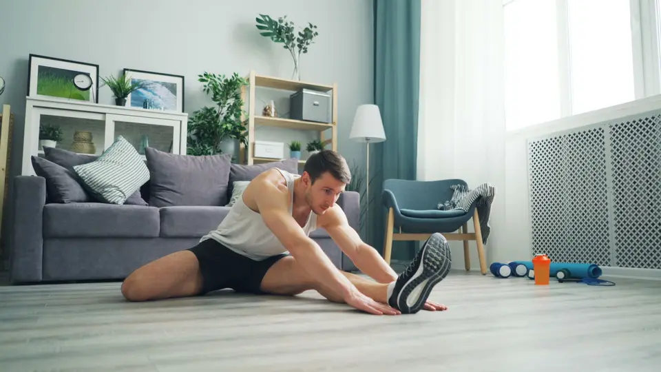 Man stretching on floor at home